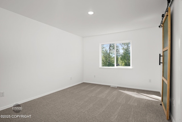 1460 E Esty Dr, Palmer, AK 99645 - empty room featuring dark colored carpet, a barn door, and recessed lighting