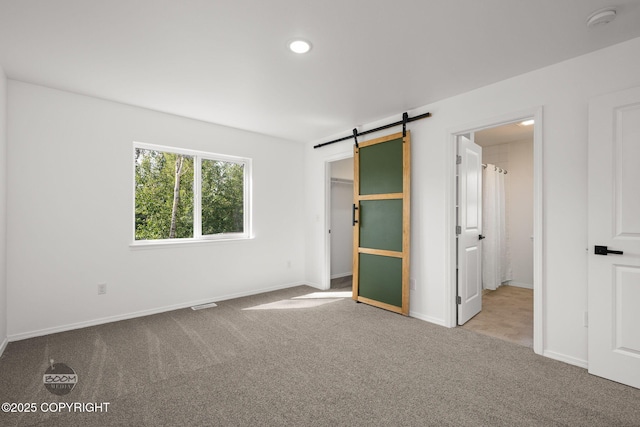 1460 E Esty Dr, Palmer, AK 99645 - unfurnished bedroom with carpet flooring, a barn door, a walk in closet, and recessed lighting