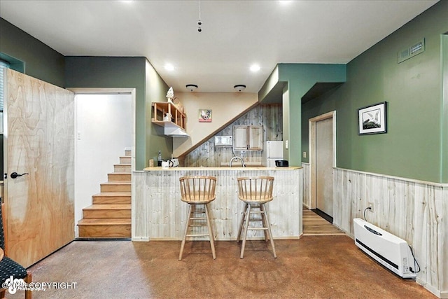 18095 Langille Rd, Cooper Landing, AK 99572 - kitchen featuring freestanding refrigerator, wainscoting, a peninsula, carpet flooring, and a kitchen breakfast bar