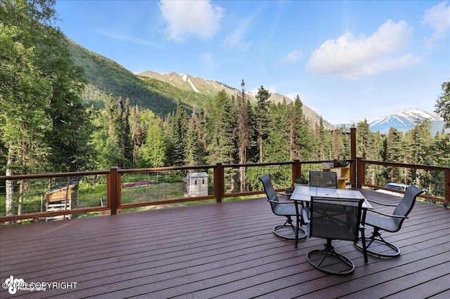 18095 Langille Rd, Cooper Landing, AK 99572 - wooden deck with outdoor dining area, a mountain view, and a forest view
