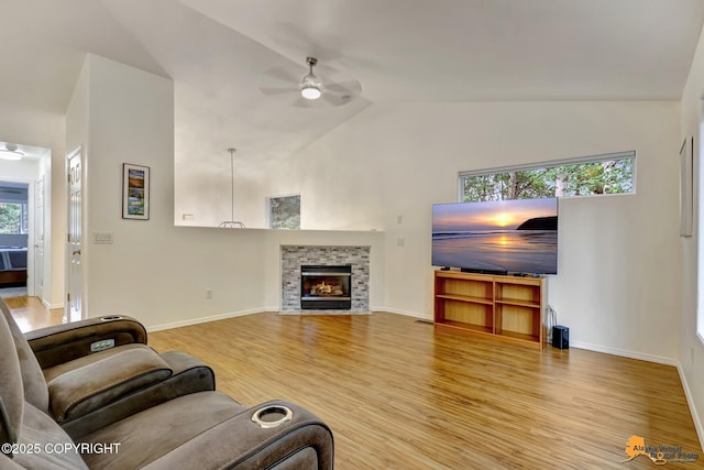 7862 Spruce St Unit 7B, Anchorage, AK 99507 - living room featuring ceiling fan, wood finished floors, high vaulted ceiling, and a stone fireplace