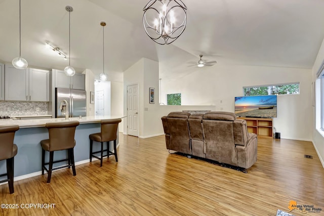 7862 Spruce St Unit 7B, Anchorage, AK 99507 - living area with lofted ceiling, light wood-style floors, ceiling fan, and a chandelier