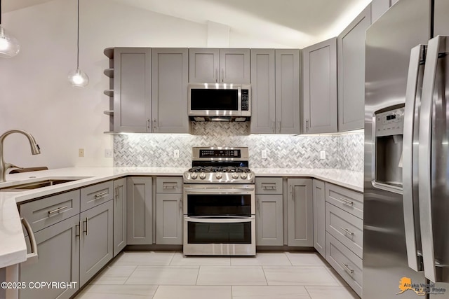 7862 Spruce St Unit 7B, Anchorage, AK 99507 - kitchen featuring appliances with stainless steel finishes, gray cabinets, light countertops, backsplash, and lofted ceiling