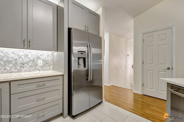 7862 Spruce St Unit 7B, Anchorage, AK 99507 - kitchen featuring appliances with stainless steel finishes, gray cabinets, tasteful backsplash, and light countertops