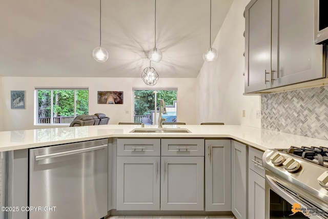 7862 Spruce St Unit 7B, Anchorage, AK 99507 - kitchen with stainless steel dishwasher, gray cabinets, backsplash, a peninsula, and open floor plan