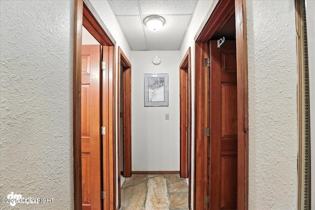 311 Alpine Meadows Ave, Girdwood, AK 99587 - hallway featuring a textured wall, stone finish floors, and a paneled ceiling