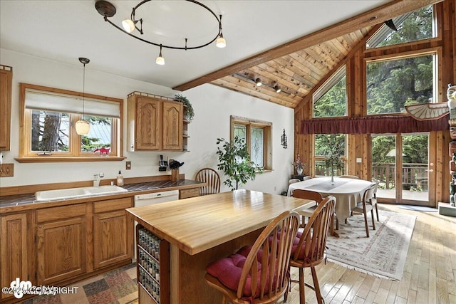 311 Alpine Meadows Ave, Girdwood, AK 99587 - kitchen featuring wooden counters, beamed ceiling, light wood-style flooring, a kitchen island, and hanging light fixtures