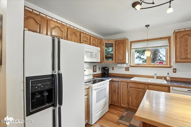 311 Alpine Meadows Ave, Girdwood, AK 99587 - kitchen featuring white appliances, brown cabinetry, light wood-style floors, and hanging light fixtures