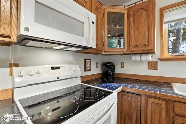 311 Alpine Meadows Ave, Girdwood, AK 99587 - kitchen featuring white appliances, tile counters, brown cabinetry, and glass insert cabinets