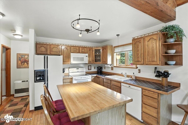 311 Alpine Meadows Ave, Girdwood, AK 99587 - kitchen with white appliances, brown cabinetry, light wood-style flooring, glass insert cabinets, and hanging light fixtures