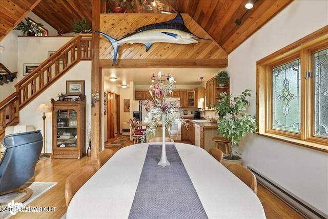 311 Alpine Meadows Ave, Girdwood, AK 99587 - dining room with a baseboard heating unit, wooden ceiling, lofted ceiling, stairs, and light wood-style flooring