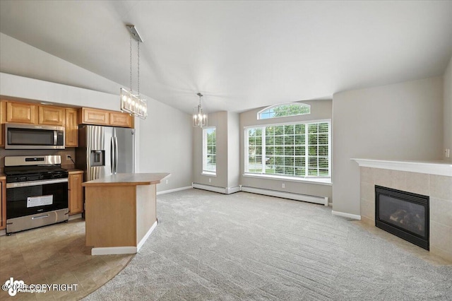 5612 E Beaver Ave, Wasilla, AK 99654 - kitchen with appliances with stainless steel finishes, open floor plan, a tile fireplace, lofted ceiling, and a chandelier