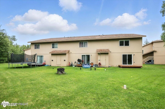 5612 E Beaver Ave, Wasilla, AK 99654 - back of property with an outdoor fire pit, a trampoline, and a yard