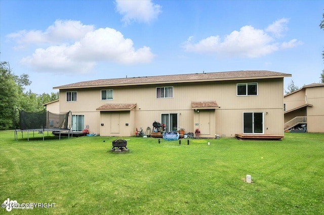 5612 E Beaver Ave, Wasilla, AK 99654 - rear view of property with a fire pit, a trampoline, and a lawn