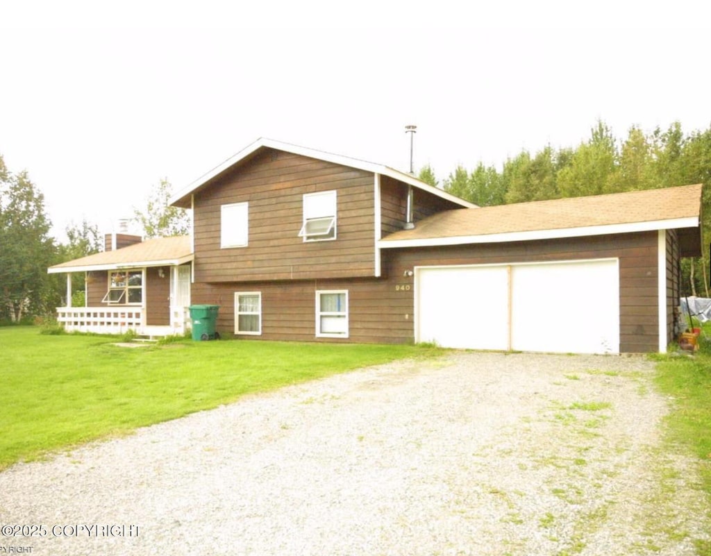 940 S Serrano Dr, Wasilla, AK 99654 - split level home with a garage, gravel driveway, a front lawn, and a porch