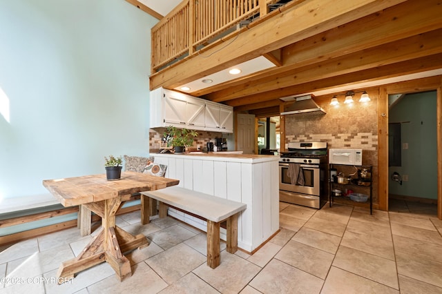 40996 Woodman Ln, Homer, AK 99603 - kitchen with stainless steel gas range, white microwave, decorative backsplash, wall chimney exhaust hood, and white cabinetry