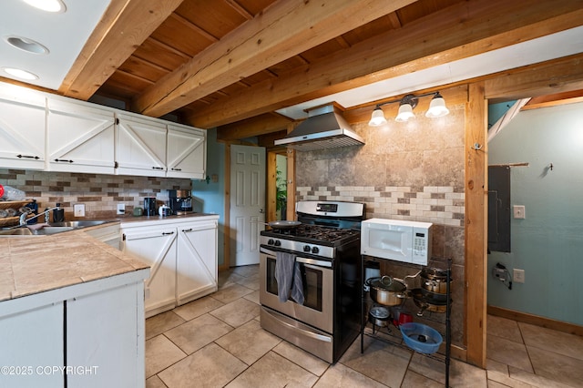 40996 Woodman Ln, Homer, AK 99603 - kitchen featuring stainless steel range with gas stovetop, exhaust hood, white microwave, tasteful backsplash, and a wooden ceiling with exposed beams