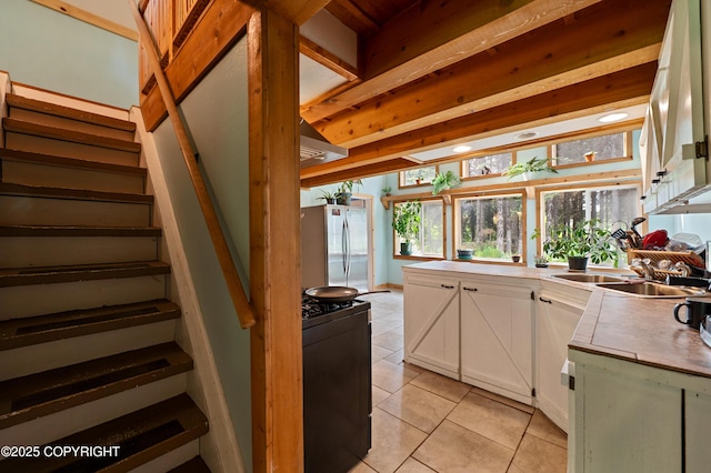 40996 Woodman Ln, Homer, AK 99603 - kitchen with freestanding refrigerator, light tile patterned floors, stove, white cabinets, and light countertops