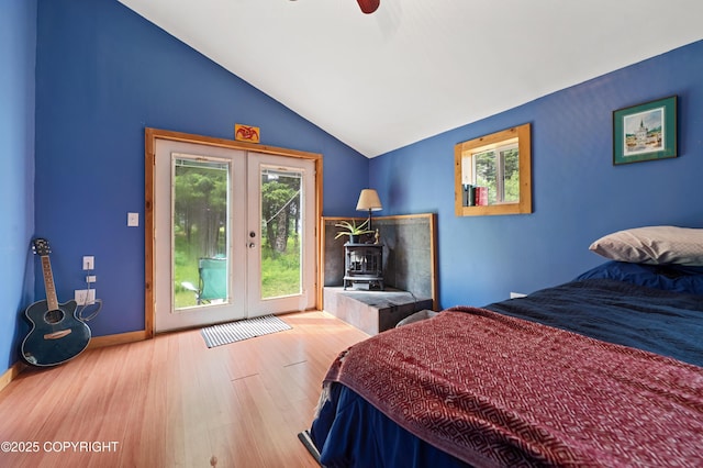40996 Woodman Ln, Homer, AK 99603 - bedroom featuring a wood stove, access to outside, french doors, multiple windows, and vaulted ceiling