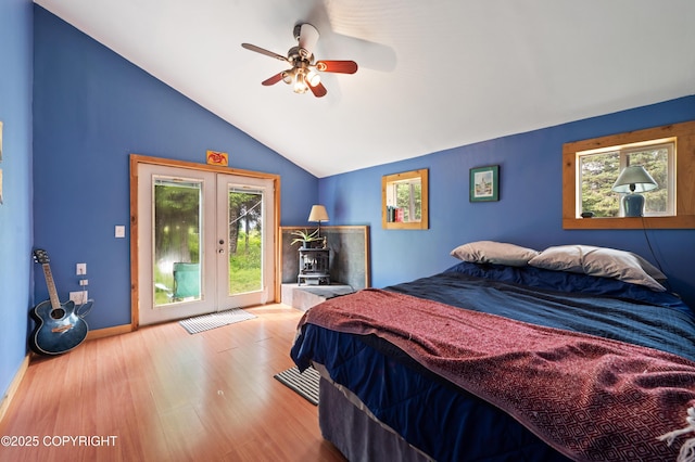 40996 Woodman Ln, Homer, AK 99603 - bedroom featuring multiple windows, vaulted ceiling, access to outside, a wood stove, and wood finished floors