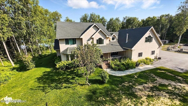 9803 W King Arthur Dr, Wasilla, AK 99623 - view of front of house with a front lawn, covered porch, view of scattered trees, and asphalt driveway