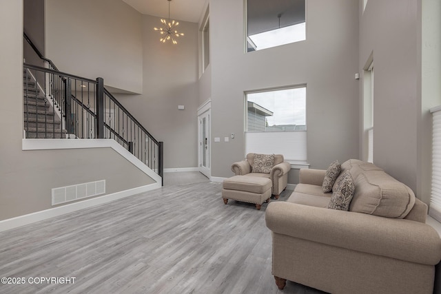 5062 E Calf Cir, Wasilla, AK 99654 - living room with a high ceiling, plenty of natural light, a chandelier, wood finished floors, and stairs