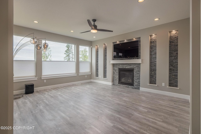 5062 E Calf Cir, Wasilla, AK 99654 - unfurnished living room featuring a ceiling fan, a stone fireplace, recessed lighting, and wood finished floors