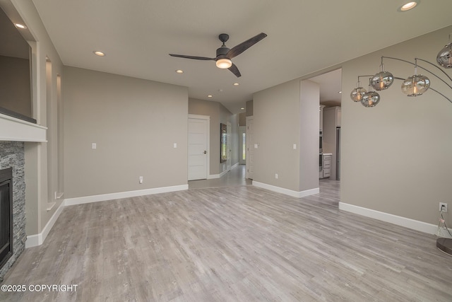 5062 E Calf Cir, Wasilla, AK 99654 - unfurnished living room with a stone fireplace, a ceiling fan, light wood finished floors, and recessed lighting