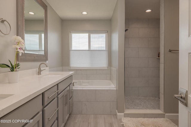 5062 E Calf Cir, Wasilla, AK 99654 - full bathroom featuring a garden tub, double vanity, wood finished floors, tiled shower, and recessed lighting