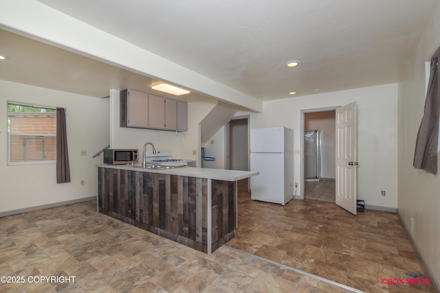 20057 E Caswell Lakes Rd, Willow, AK 99688 - kitchen featuring white appliances, stone finish floors, a peninsula, light countertops, and recessed lighting