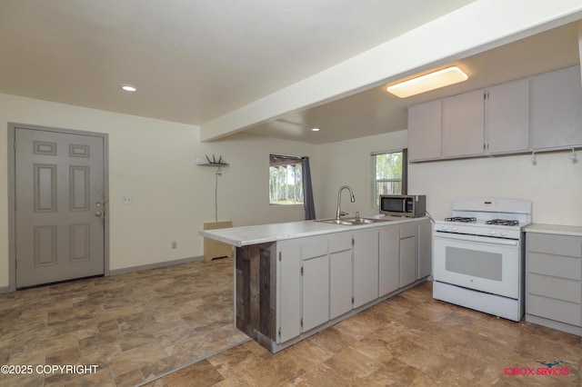 20057 E Caswell Lakes Rd, Willow, AK 99688 - kitchen with gas range gas stove, a peninsula, stone finish flooring, stainless steel microwave, and light countertops