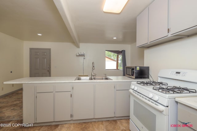 20057 E Caswell Lakes Rd, Willow, AK 99688 - kitchen with white range with gas cooktop, stainless steel microwave, a peninsula, light countertops, and beam ceiling