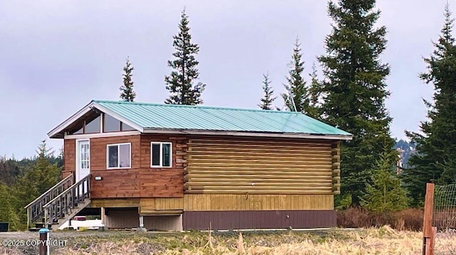 68021 Jolly Ave, Anchor Point, AK 99556 - view of home's exterior with log siding, a metal roof, and stairs