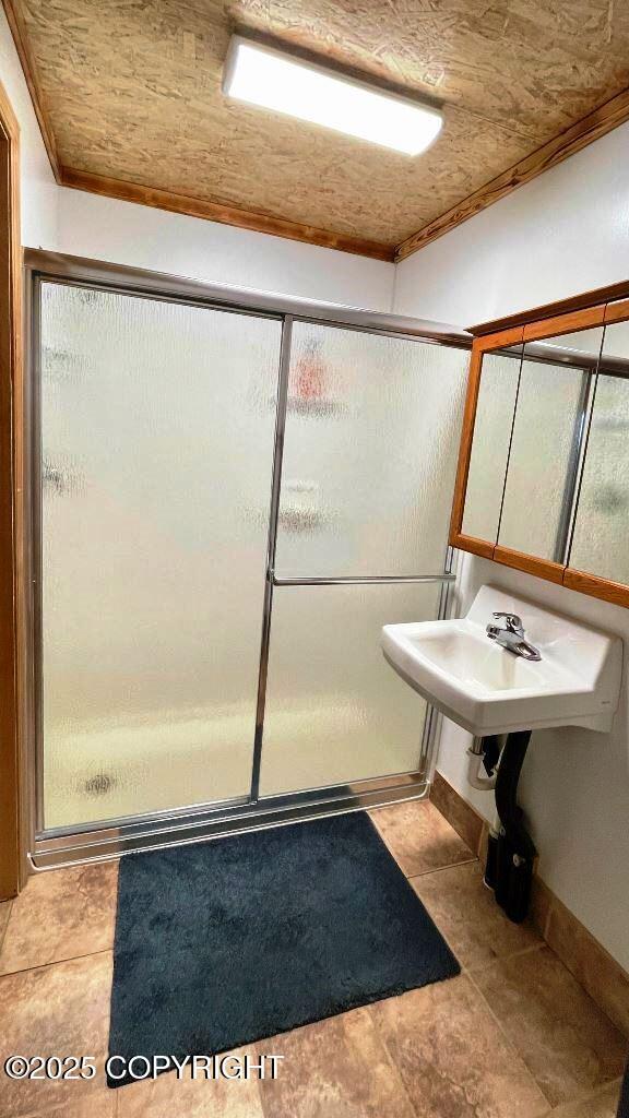 68021 Jolly Ave, Anchor Point, AK 99556 - full bathroom with a stall shower, ornamental molding, and tile patterned flooring