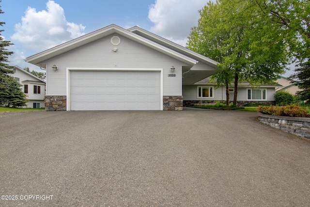 1103 Inlet Woods Dr, Kenai, AK 99611 - view of front of home featuring stone siding, an attached garage, and driveway