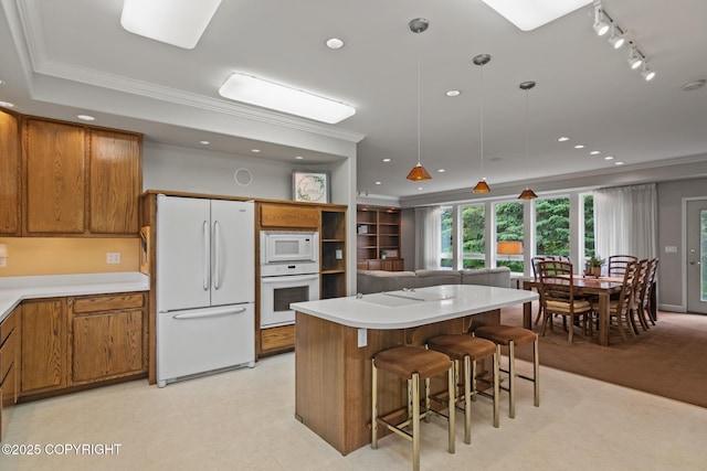1103 Inlet Woods Dr, Kenai, AK 99611 - kitchen featuring white appliances, brown cabinetry, crown molding, decorative light fixtures, and track lighting