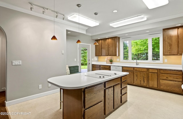 1103 Inlet Woods Dr, Kenai, AK 99611 - kitchen with brown cabinetry, crown molding, track lighting, a kitchen island, and light countertops