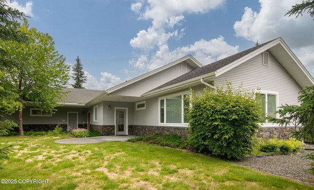 1103 Inlet Woods Dr, Kenai, AK 99611 - view of front of home featuring a patio area, a front lawn, stone siding, and roof with shingles