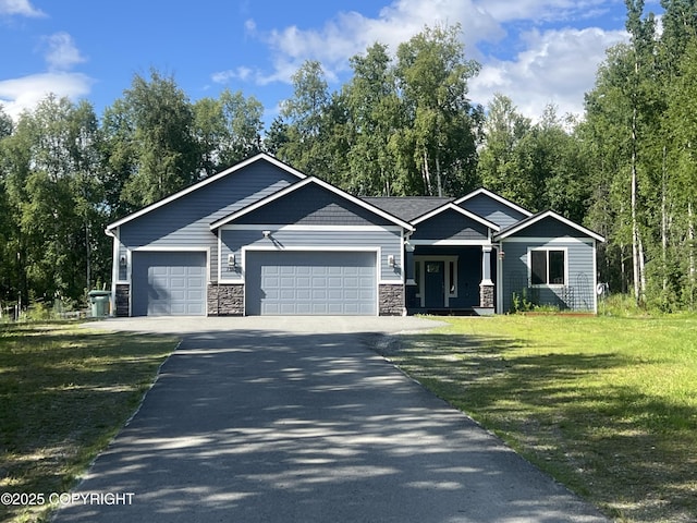 1380 S Countrywood Dr, Wasilla, AK 99623 - view of front of house featuring asphalt driveway, an attached garage, a front yard, stone siding, and covered porch