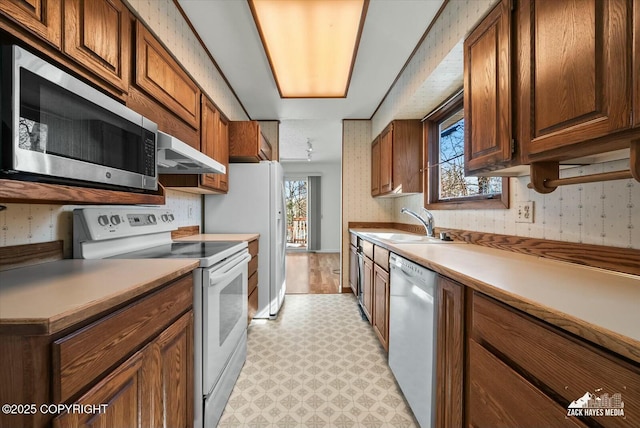 1521 Cache Dr, Anchorage, AK 99507 - kitchen featuring white appliances, light flooring, under cabinet range hood, wallpapered walls, and light countertops