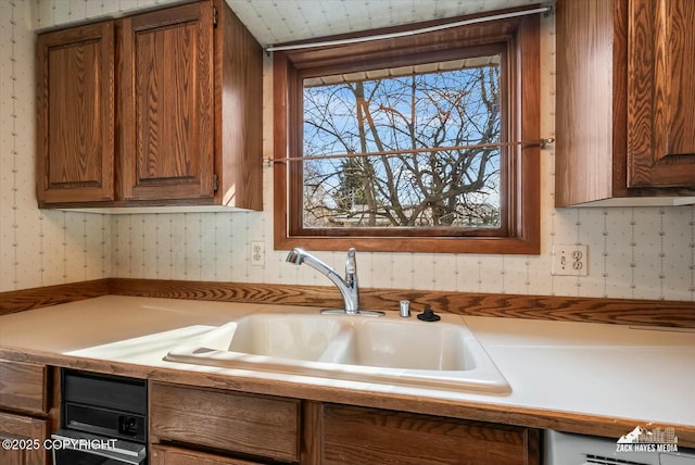 1521 Cache Dr, Anchorage, AK 99507 - kitchen with wallpapered walls, light countertops, and brown cabinets