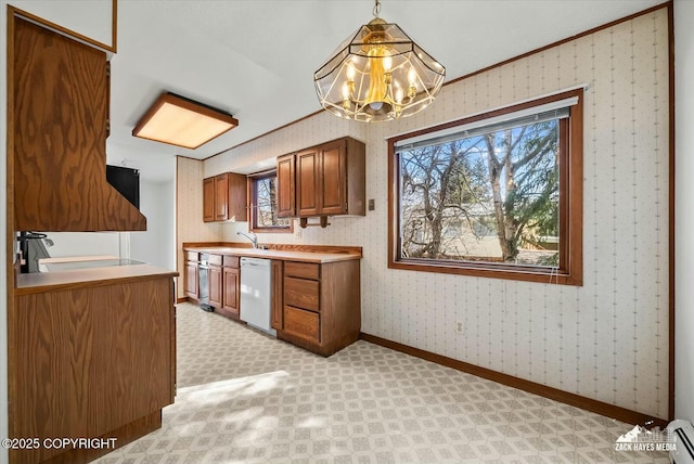 1521 Cache Dr, Anchorage, AK 99507 - kitchen with plenty of natural light, brown cabinetry, wallpapered walls, white dishwasher, and a chandelier