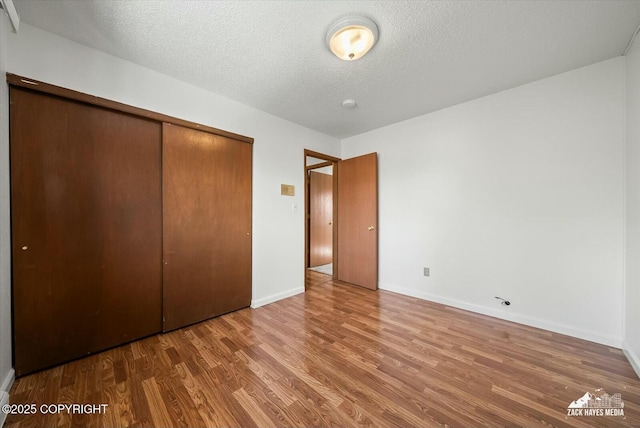 1521 Cache Dr, Anchorage, AK 99507 - unfurnished bedroom featuring wood finished floors, a closet, and a textured ceiling