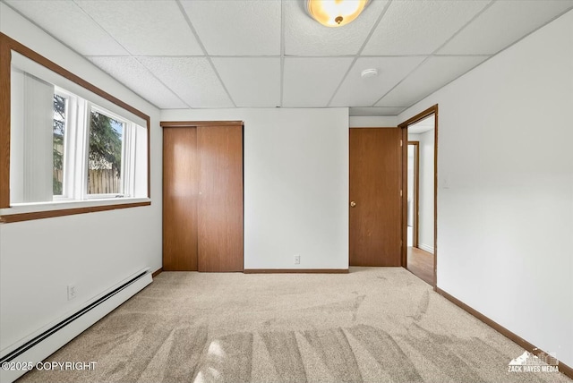 1521 Cache Dr, Anchorage, AK 99507 - unfurnished bedroom featuring a baseboard radiator, a drop ceiling, carpet floors, and a closet