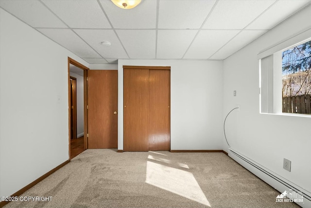 1521 Cache Dr, Anchorage, AK 99507 - unfurnished bedroom featuring a baseboard radiator, a paneled ceiling, carpet flooring, and a closet