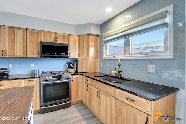 3265 Montclair Ct # 17E, Anchorage, AK 99503 - kitchen featuring stainless steel gas range oven, decorative backsplash, light brown cabinets, light wood-style flooring, and dark stone counters