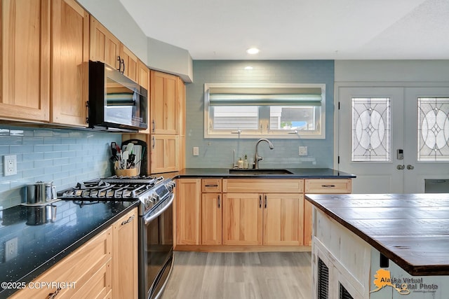 3265 Montclair Ct # 17E, Anchorage, AK 99503 - kitchen featuring range with gas cooktop, stainless steel microwave, decorative backsplash, light wood finished floors, and butcher block countertops