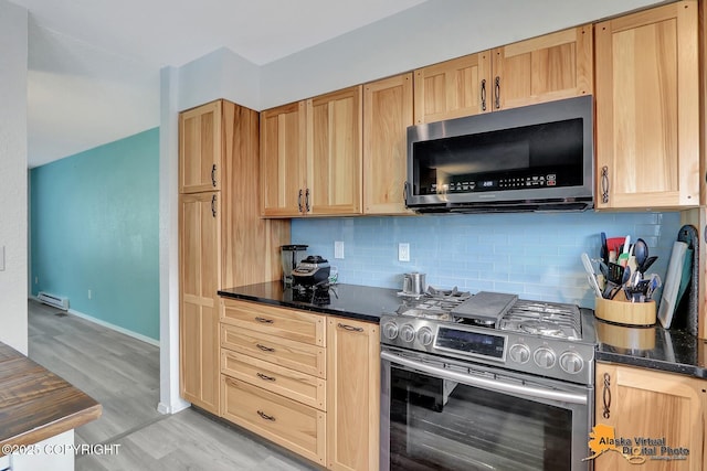 3265 Montclair Ct # 17E, Anchorage, AK 99503 - kitchen featuring appliances with stainless steel finishes, decorative backsplash, light wood-type flooring, and a baseboard heating unit