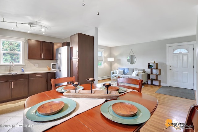 3306 E 19th Ct, Anchorage, AK 99508 - dining space featuring healthy amount of natural light, light wood-style flooring, and a baseboard heating unit