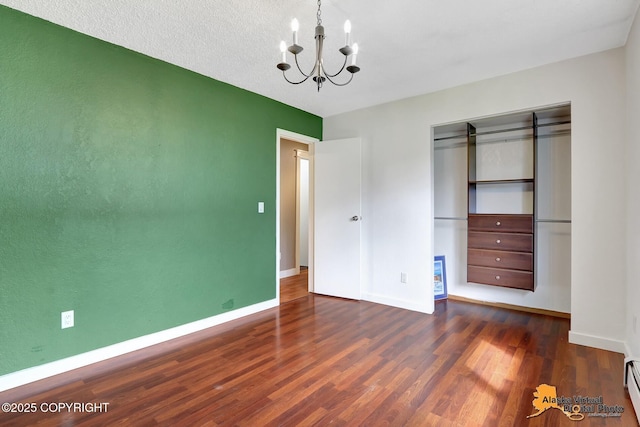 3306 E 19th Ct, Anchorage, AK 99508 - unfurnished bedroom featuring wood finished floors, a chandelier, a closet, and a baseboard heating unit